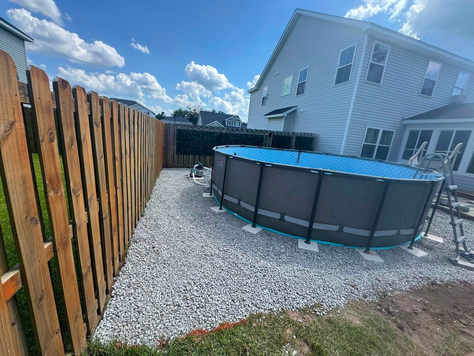 Finished pool and gravel area with a privacy fence